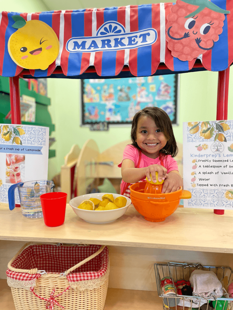 A Kinder Prep child squeezing lemons at the classroom pretend market in our Brooklyn Heights Universal 3-K program