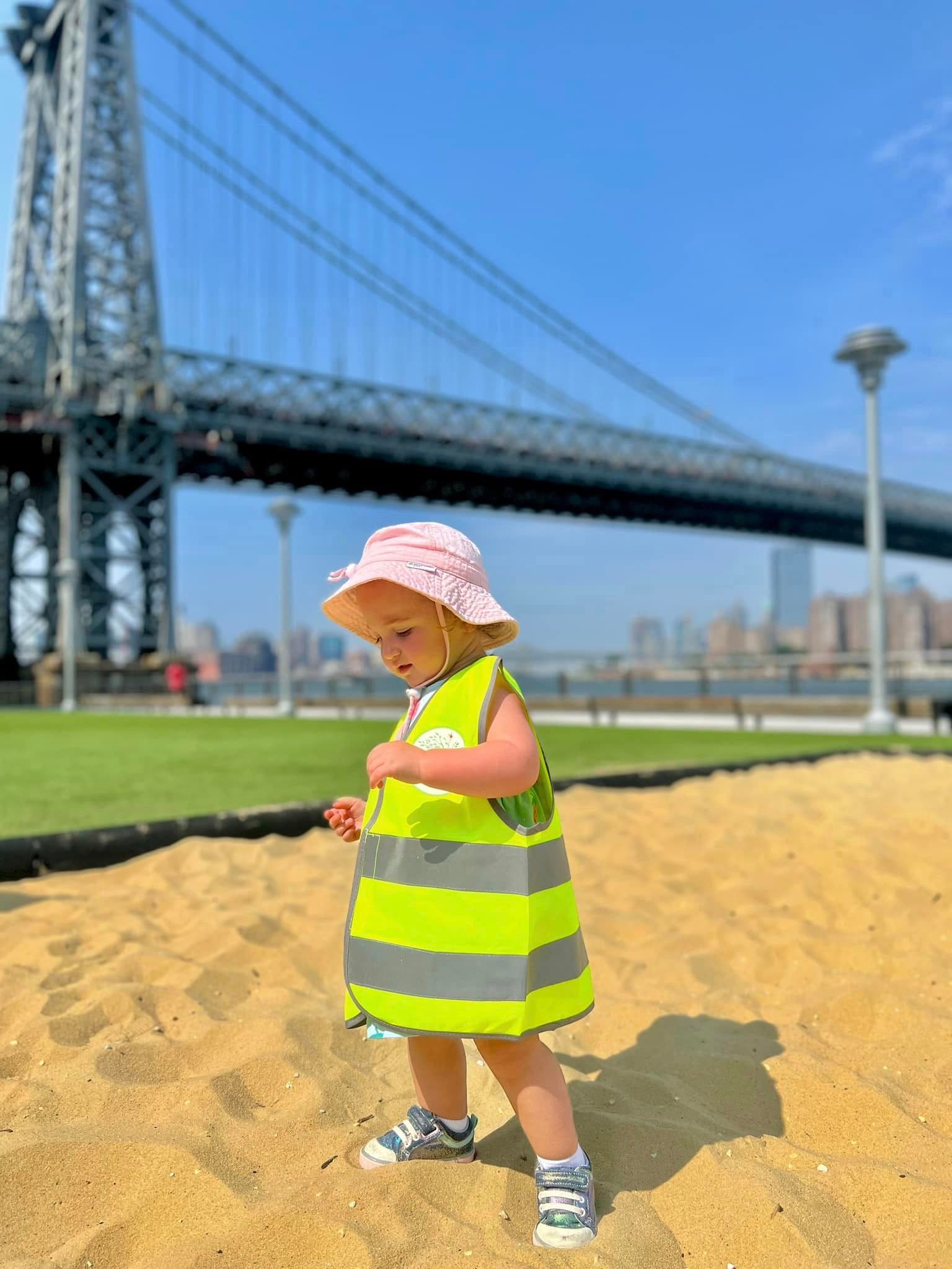 Children at beach with Williamsburg Bridge