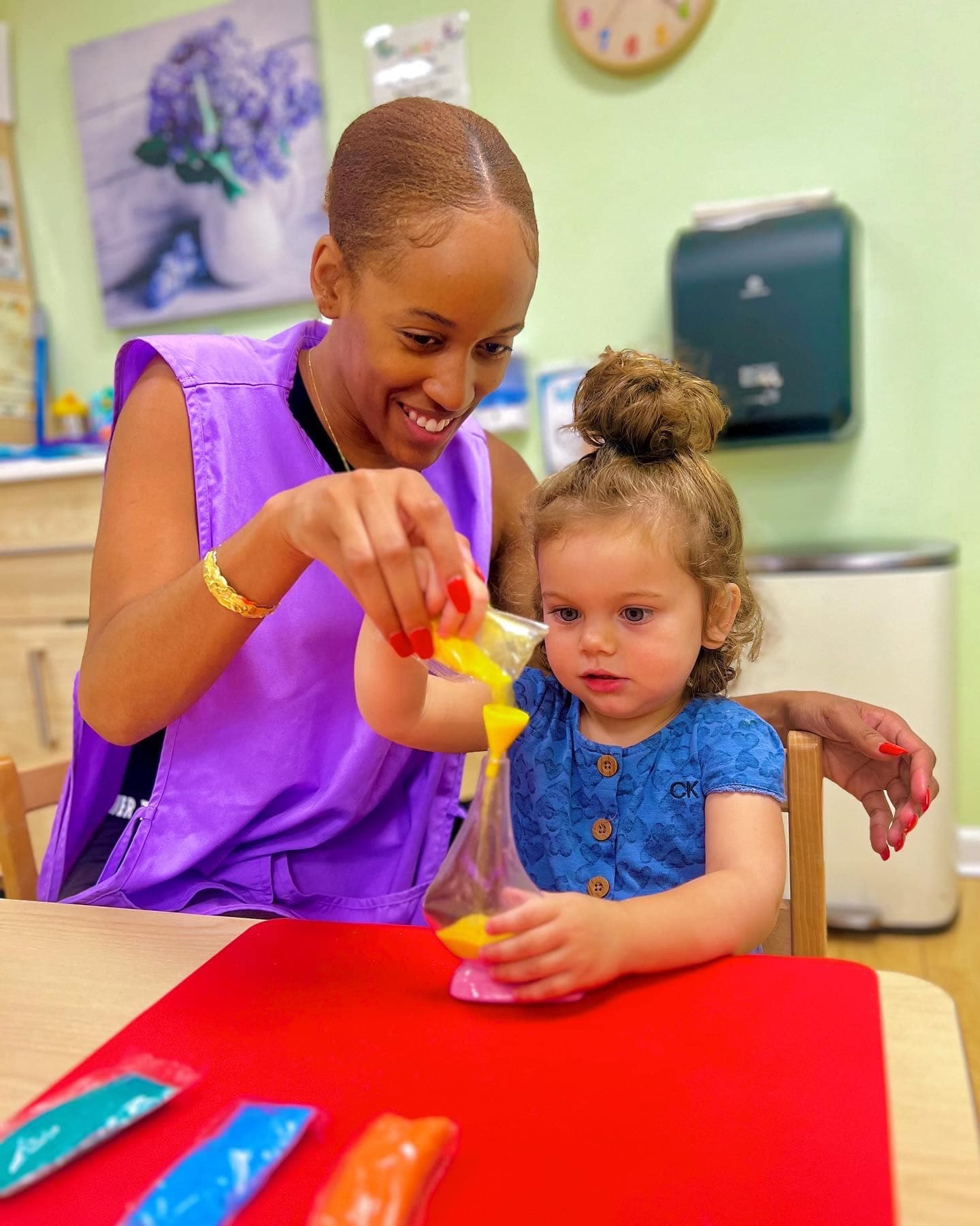 Teacher and early preschooler exploring a colorful sensory bag together