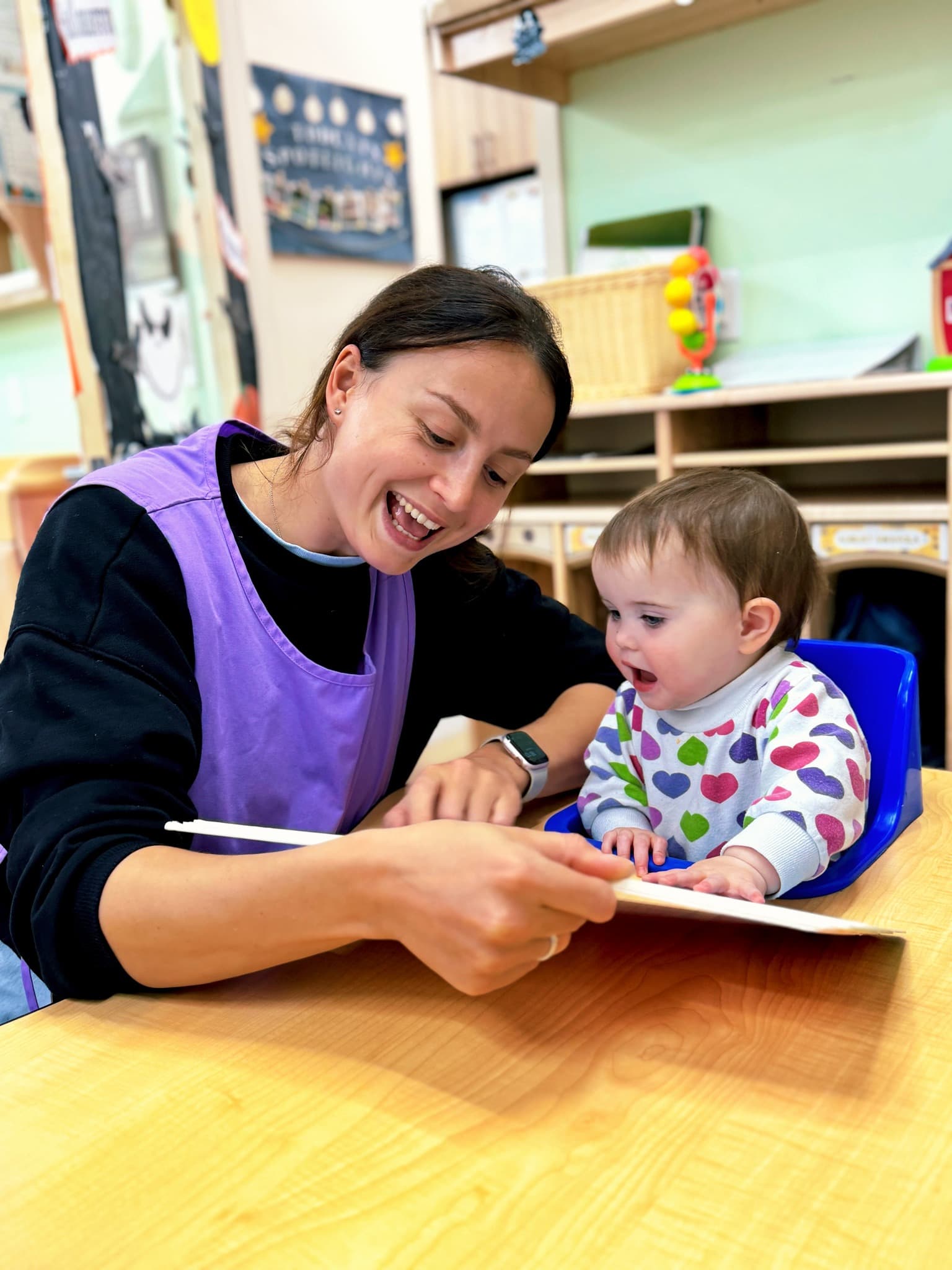 Teacher helping child with handprint art activity