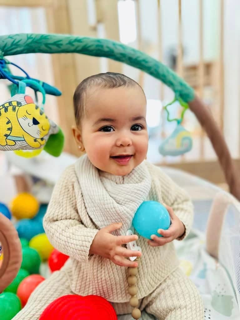 Happy infant exploring sensory toys