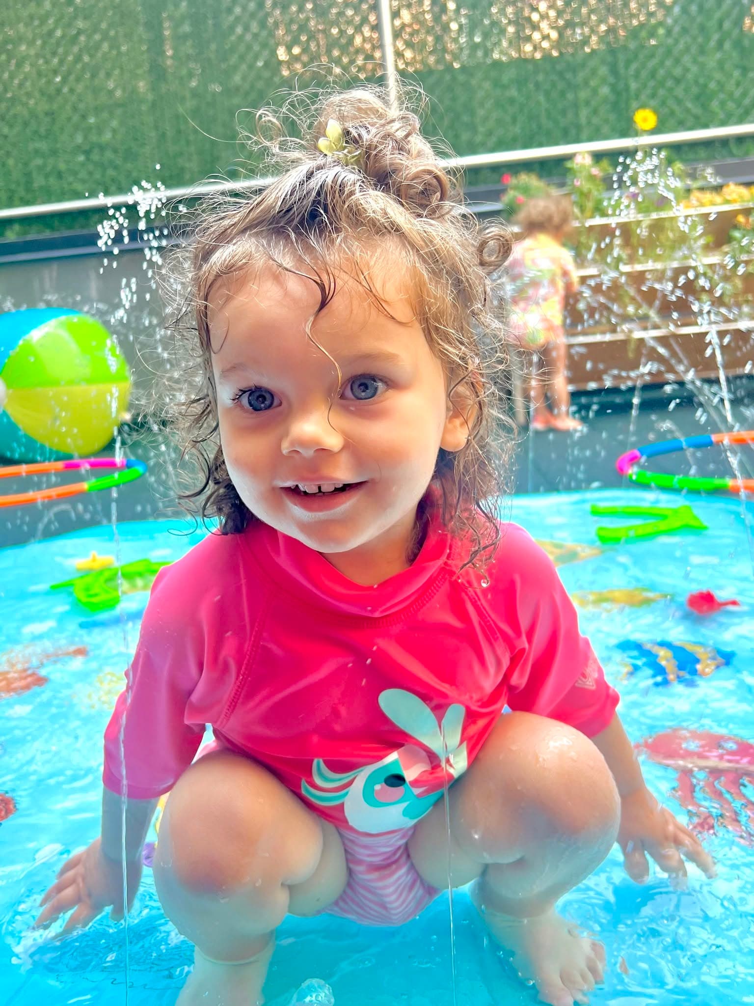 Smiling toddler playing in the splash pad at Kinder Prep summer camp in Brooklyn Heights