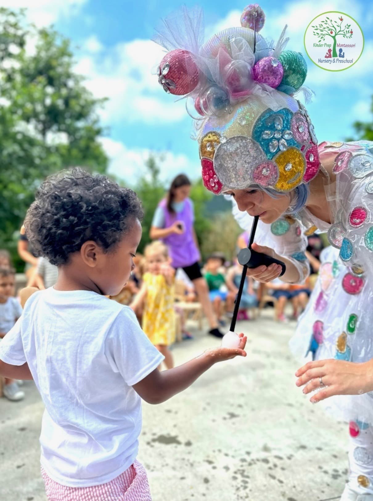 Child enjoying a special outdoor performance at Kinder Prep summer camp