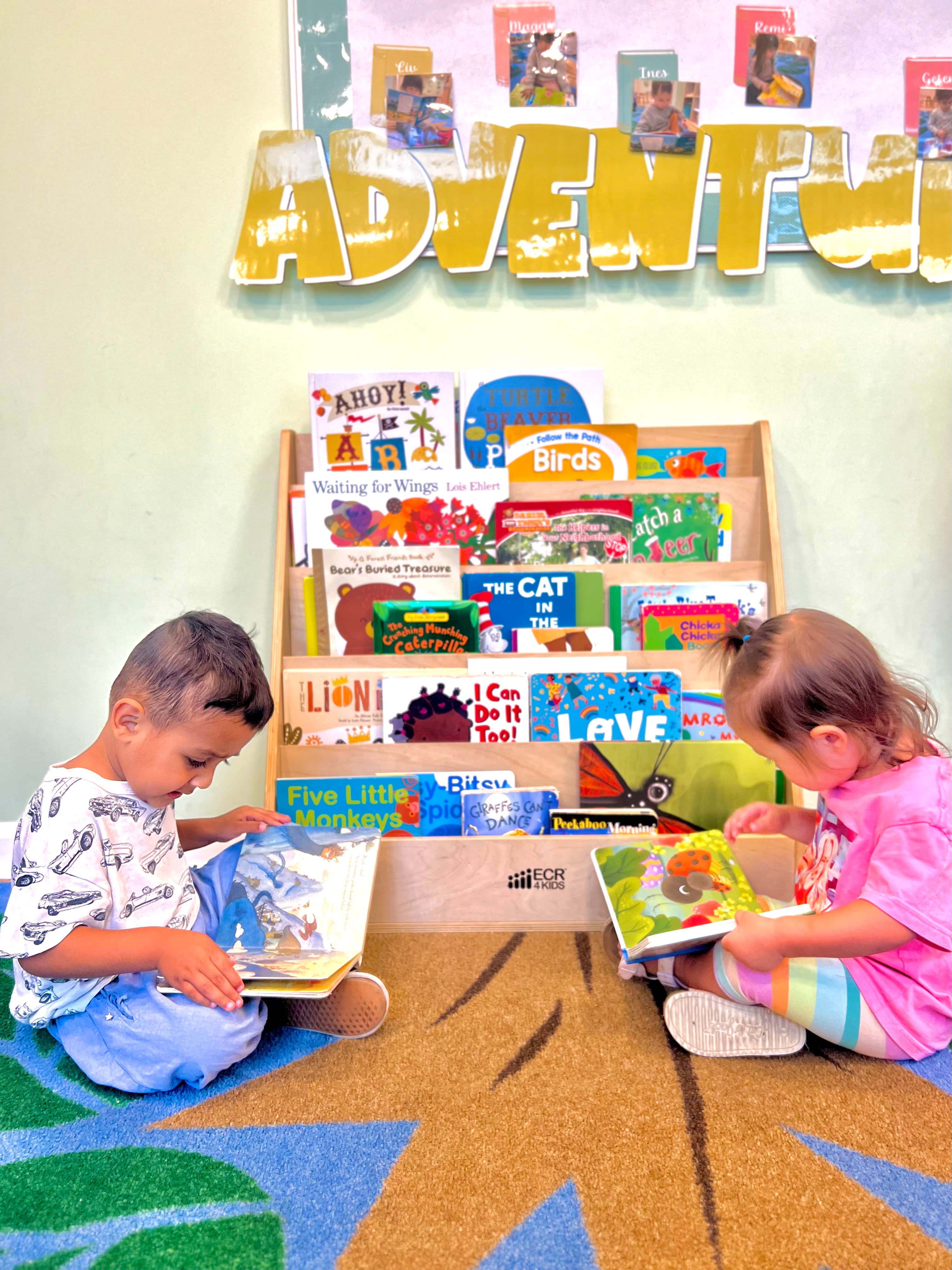Preschoolers reading board books in the classroom book nook