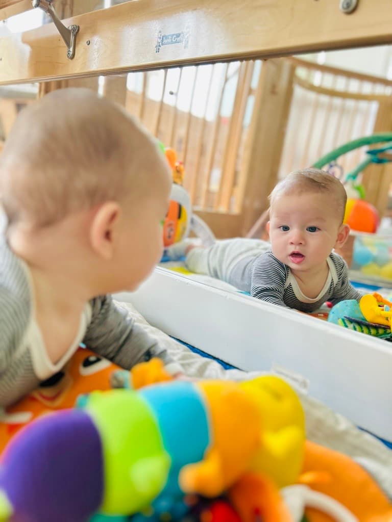 Infant during tummy time with a Montessori mirror